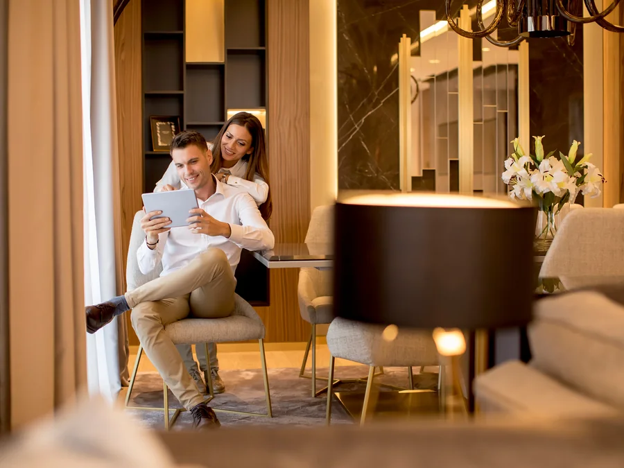 Two people sitting together reviewing a tablet in a warmly lit living room.