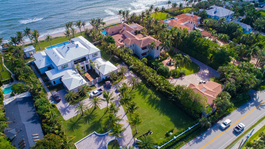 Aerial view along a South Florida beach, showing a long coastal strip, blue water and a populated shoreline.